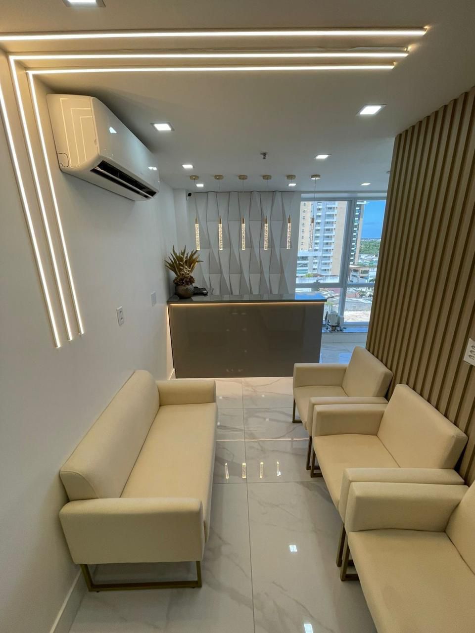 Sala de espera do Instituto Odontológico Gold com sofá e recepção ao fundo
